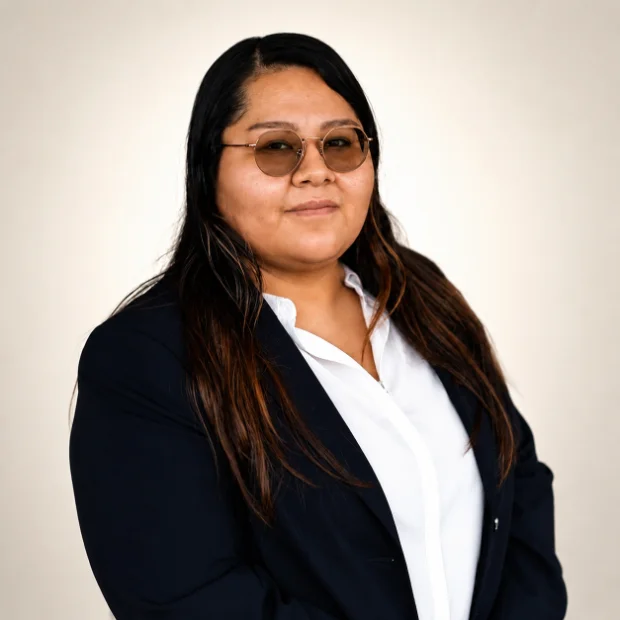 Professional woman in navy blazer and sunglasses smiling