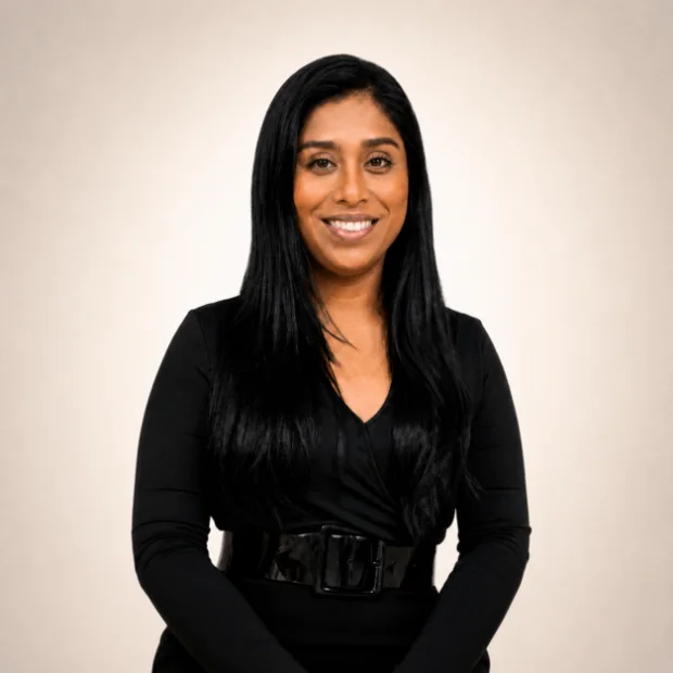 Smiling woman in black outfit with belt posing professionally